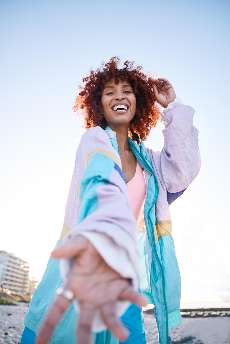 Foto retrato de mujer feliz y oferta de mano amiga o invitación en la playa en un espacio de maqueta de ángulo bajo palma de sonrisa y persona africana brindando asistencia en atención de apoyo o aceptación de apretón de manos para dar la bienvenida