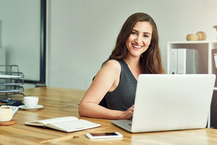 Foto retrato de una mujer feliz en la oficina con una computadora portátil para la planificación de la investigación y el correo electrónico una persona femenina sonriente y satisfecha o confiada con el crecimiento profesional o laboral como gerente de recursos humanos para una empresa corporativa