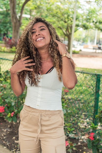 Retrato de mujer feliz de pelo rizado en el parque