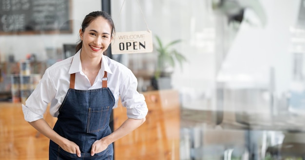 Retrato de mujer feliz de pie en la puerta de su tienda Camarera madura alegre esperando clientes en la cafetería