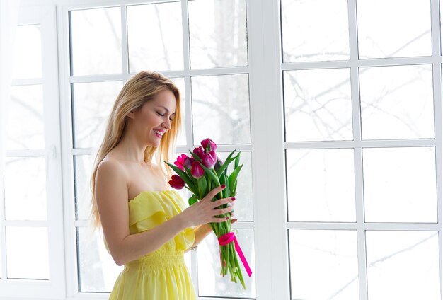 Retrato de mujer feliz con ramo de tulipanes