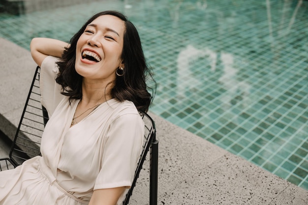 Retrato mujer feliz relajarse junto a la piscina