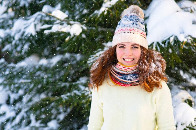 Retrato mujer feliz sobre un fondo de nieve sonrisa nieve cae sobre la niña la mujer sonríe