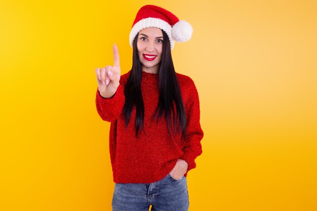 Retrato de mujer feliz y sonriente con sombrero de santa de Navidad, mostrando uno de los dedos. Contenido de descuento navideño.