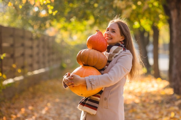 Retrato de mujer feliz sonrisa con calabazas en la mano