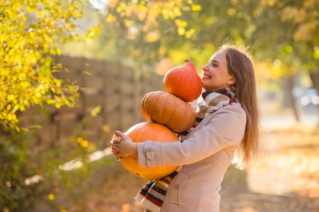 Retrato de mujer feliz sonrisa con calabazas en la mano