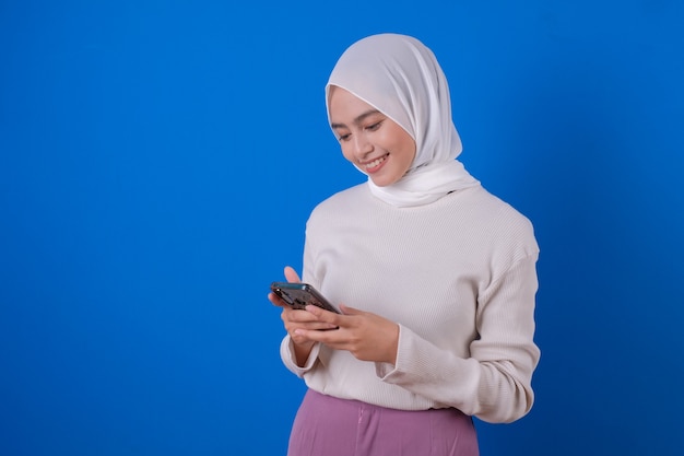 Retrato de una mujer feliz mediante teléfono móvil