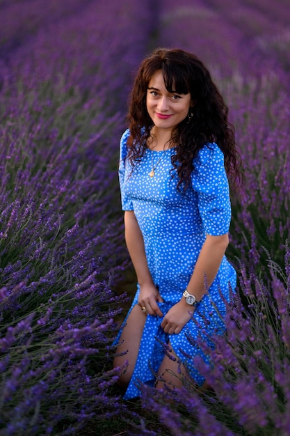 Retrato de una mujer feliz con un vestido azul disfrutando de un día soleado de verano en un campo de lavanda Aire fresco Estilo de vida