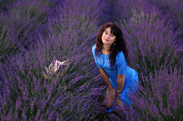 Retrato de una mujer feliz con un vestido azul disfrutando de un día soleado de verano en un campo de lavanda Aire fresco Estilo de vida