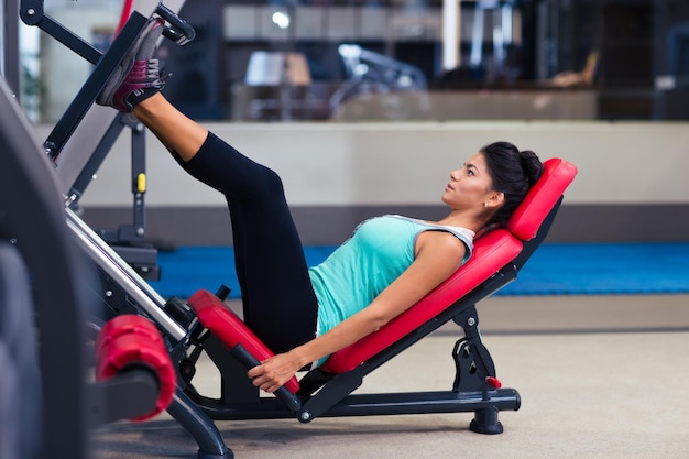 Retrato de una mujer fitness entrenamiento en máquina de ejercicios en el gimnasio