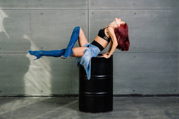 Retrato de mujer fitness en estudio sobre fondo de hormigón de cemento