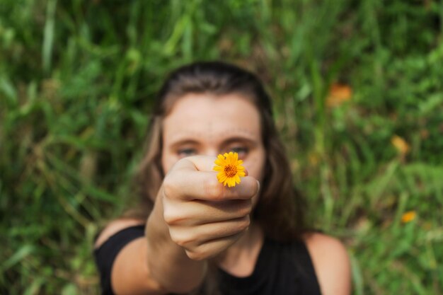 Foto retrato de una mujer con una flor amarilla