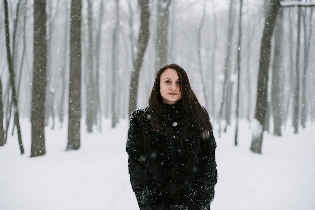 Retrato de una mujer en el fondo de un bosque nevado