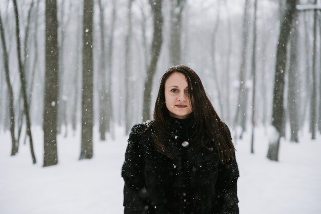 Retrato de una mujer en el fondo de un bosque nevado