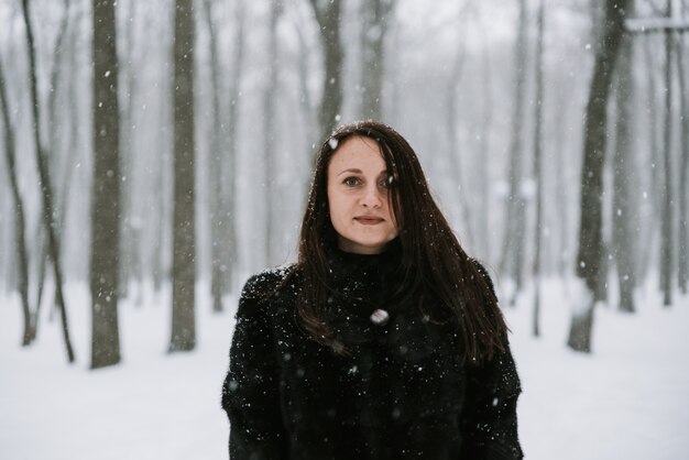 Retrato de una mujer en el fondo de un bosque nevado