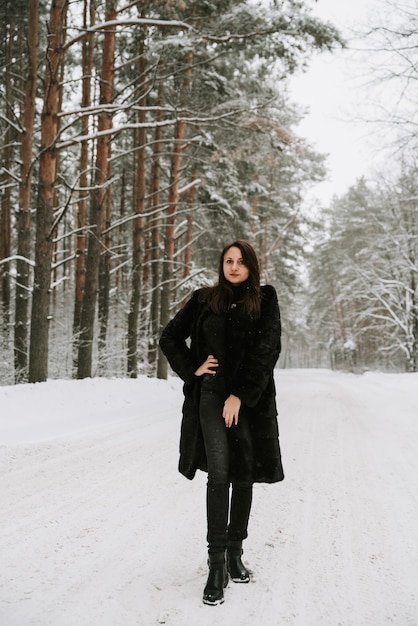 Retrato de una mujer en el fondo de un bosque nevado