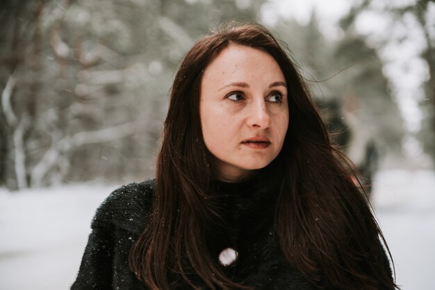 Retrato de una mujer en el fondo de un bosque nevado