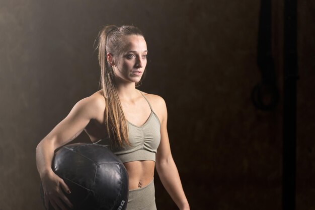 Retrato de mujer en forma concentrada sosteniendo balón medicinal