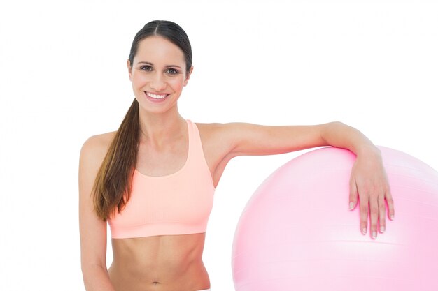 Retrato de una mujer en forma sonriente con bola de fitness