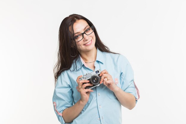 Retrato de una mujer fotografiando contra un fondo blanco