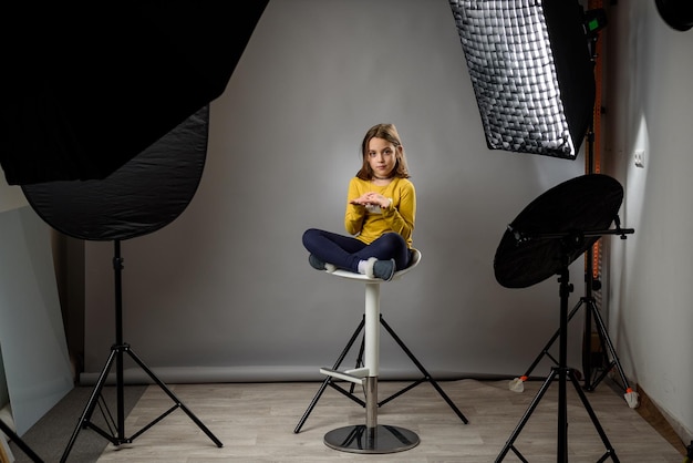 Foto retrato de una mujer fotografiando mientras está sentada en una silla