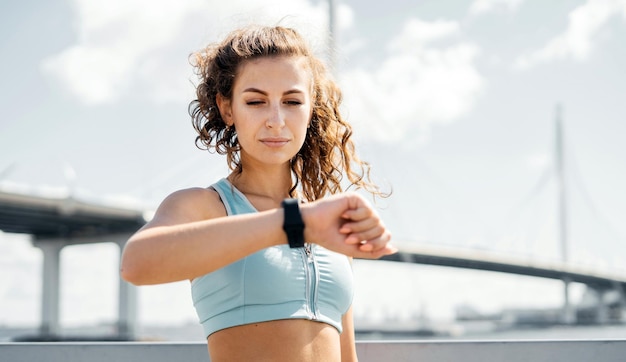 Retrato de una mujer fuerte deportiva comprueba el progreso en un reloj inteligente Una corredora mira