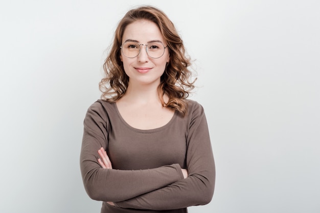 Retrato de mujer con gafas de pie cruzó las manos