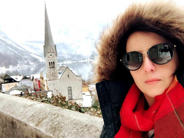 Foto retrato de una mujer con gafas de sol contra un edificio