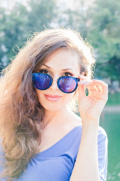 Foto retrato de una mujer con gafas de sol mientras está al aire libre