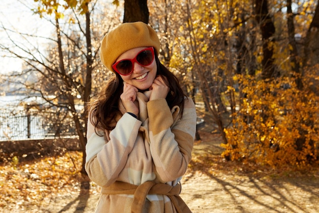 Retrato de una mujer con gafas de sol en otoño en el parque
