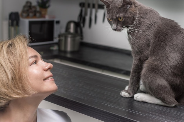 Retrato de una mujer y un gato gris de cerca