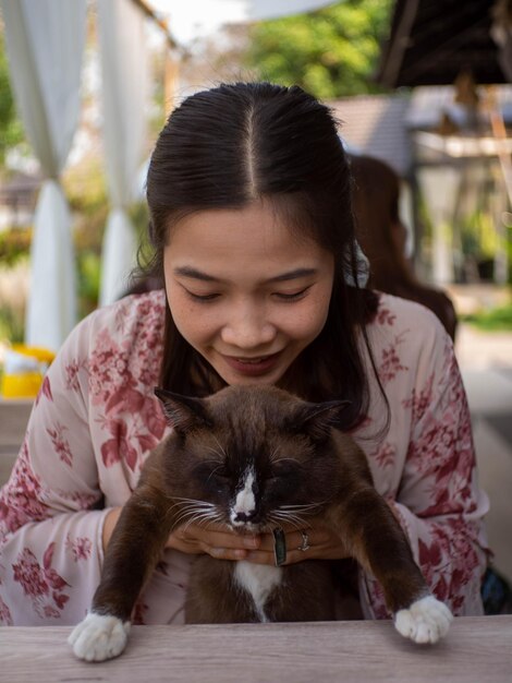 Foto retrato de una mujer con un gato con los ojos cerrados