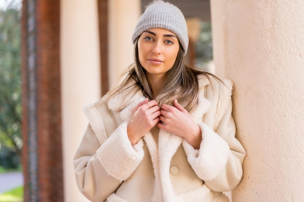 Retrato con mujer con gorro de lana en un parque de la ciudad concepto de retrato de invierno estilo de vida