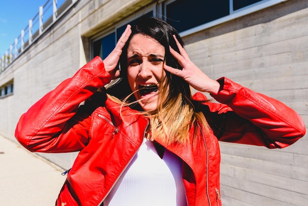 Foto retrato de una mujer gritando de pie contra la pared