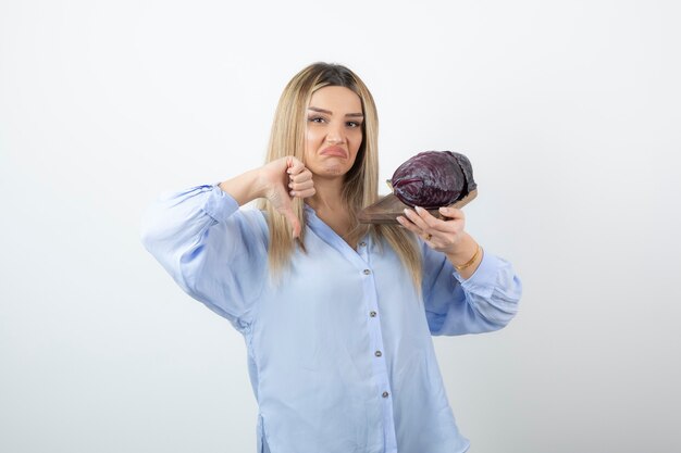 Retrato de una mujer guapa sosteniendo dos verduras repollo morado