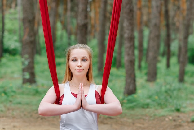 Retrato de una mujer haciendo yoga en el bosque.