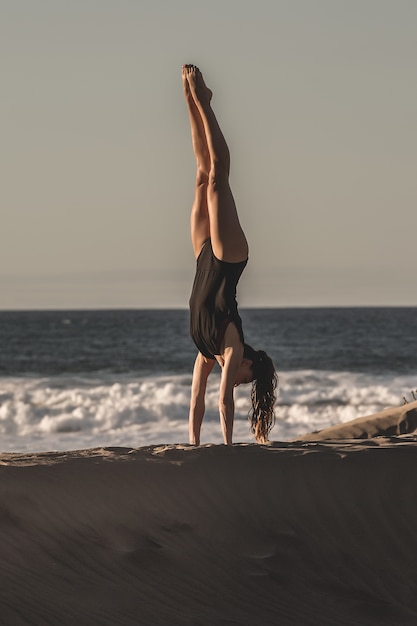 Retrato de una mujer haciendo yoga en la playa