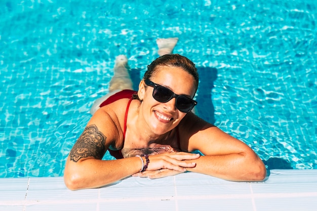 Retrato de mujer hermosa alegre en la piscina