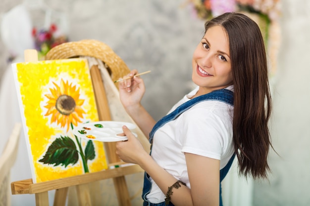 Retrato de mujer hermosa artista pintando en casa