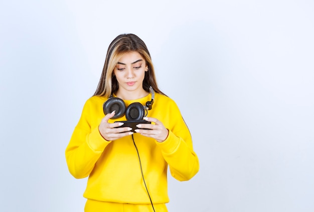 Retrato de mujer hermosa con auriculares mediante teléfono móvil