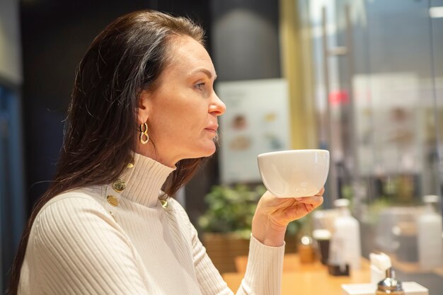 retrato, de, mujer hermosa, bebida, café, en, un, bar, en, un, café