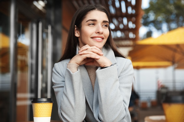 Retrato de mujer hermosa bebiendo en una cafetería.