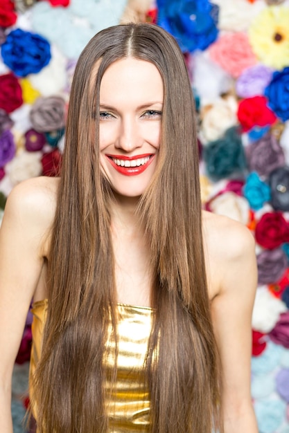 Retrato de mujer hermosa con cabello largo feliz sonriendo sobre fondo de color