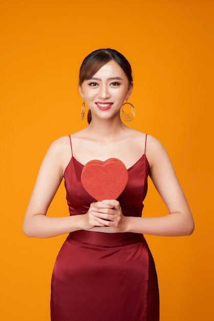 Retrato de mujer hermosa con caja en forma de corazón rojo