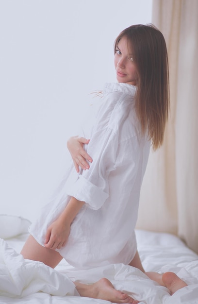 Retrato de mujer hermosa en la cama en el dormitorio