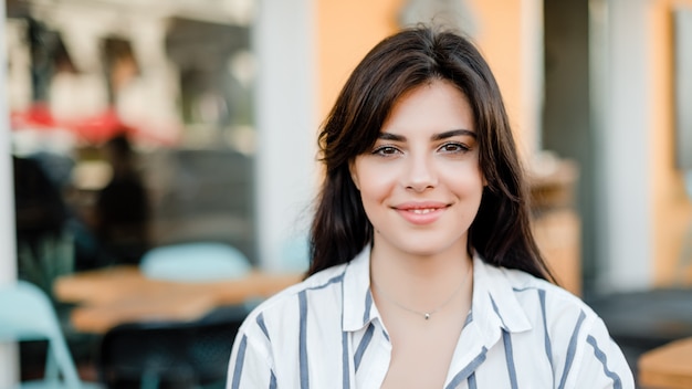 Retrato de mujer hermosa en camisa fuera de cafe