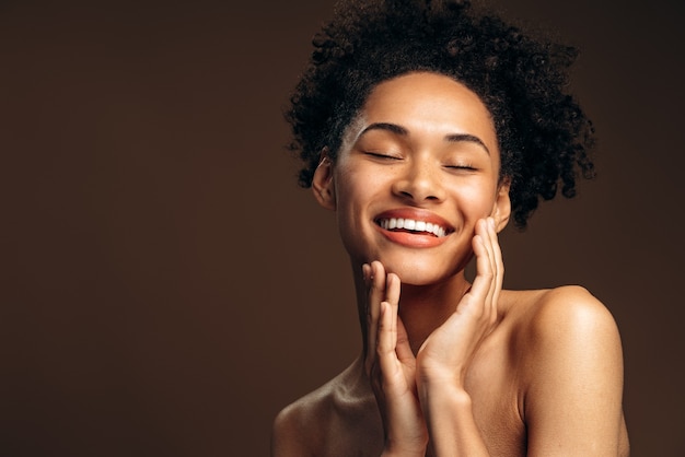 Retrato de mujer hermosa con cara bonita posando a la moda con sus manos. Rostro de mujer modelo de moda de belleza con una piel perfecta y maquillaje nude. Concepto de apariencia de mujer. Foto de stock