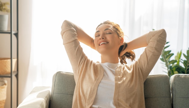 Retrato de mujer hermosa descansando en un sillón en casa