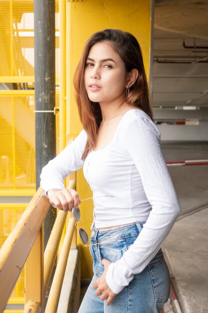 Retrato de mujer hermosa fashionista en camisa blanca y jeans azul