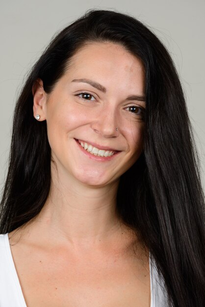 Foto retrato de mujer hermosa feliz contra la pared blanca